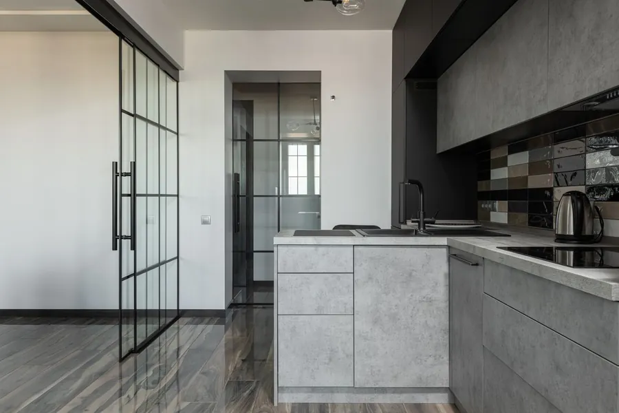 Handleless kitchen with dark matt door fronts and stone worktop in a Liverpool home