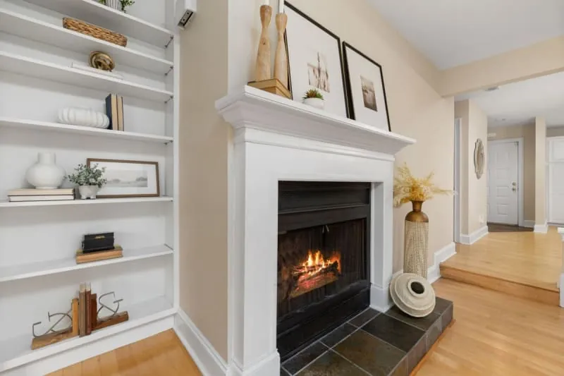 Lit fireplace with fitted shelving in the chimney breast alcove