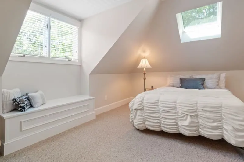 Attic bedroom with fitted furniture under a sloped ceiling