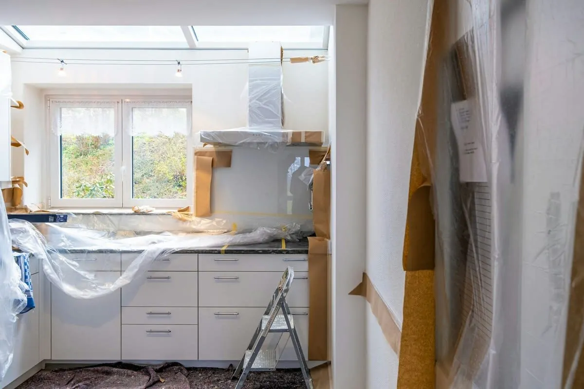 Kitchen under renovation with white cabinets and exposed walls in Liverpool