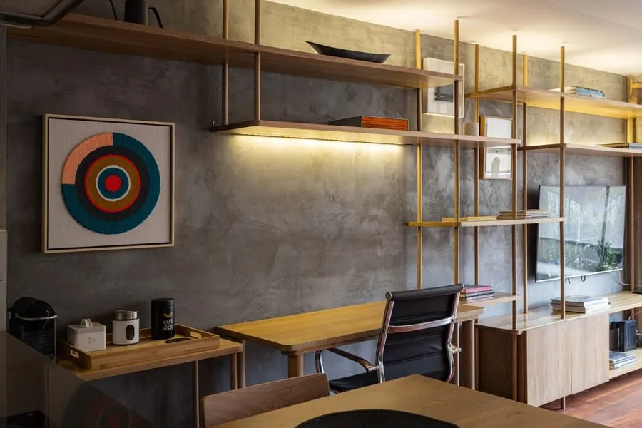 Fitted desk in a wall recess with timber shelving above it