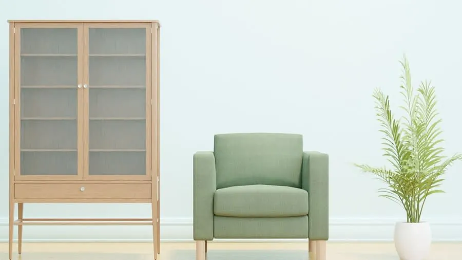 Alcove cabinet painted in a deep green with a wooden shelf and decor