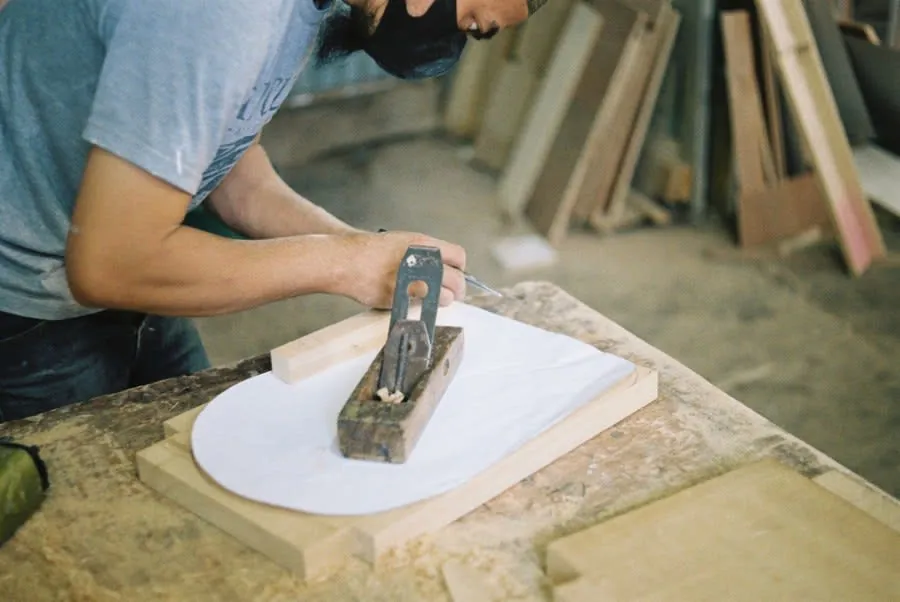 Joiner using a hand plane on a timber component at a workbench