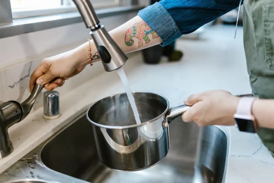 Pan being filled at a kitchen sink tap in a Liverpool home on a soft water supply