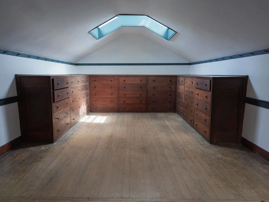 Storage room with wooden drawer units built in beneath a skylight