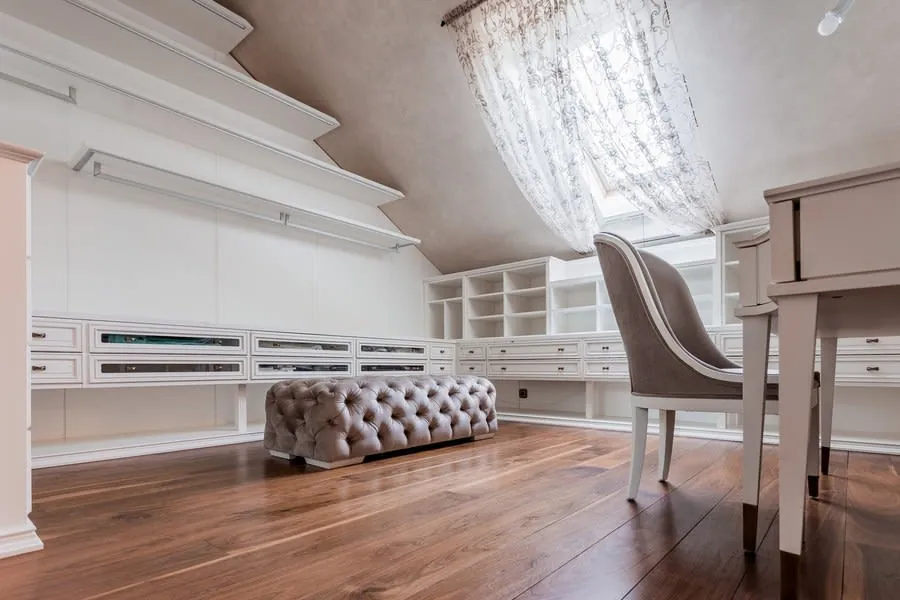 Attic room with a sloping ceiling, desk and low storage against the knee wall