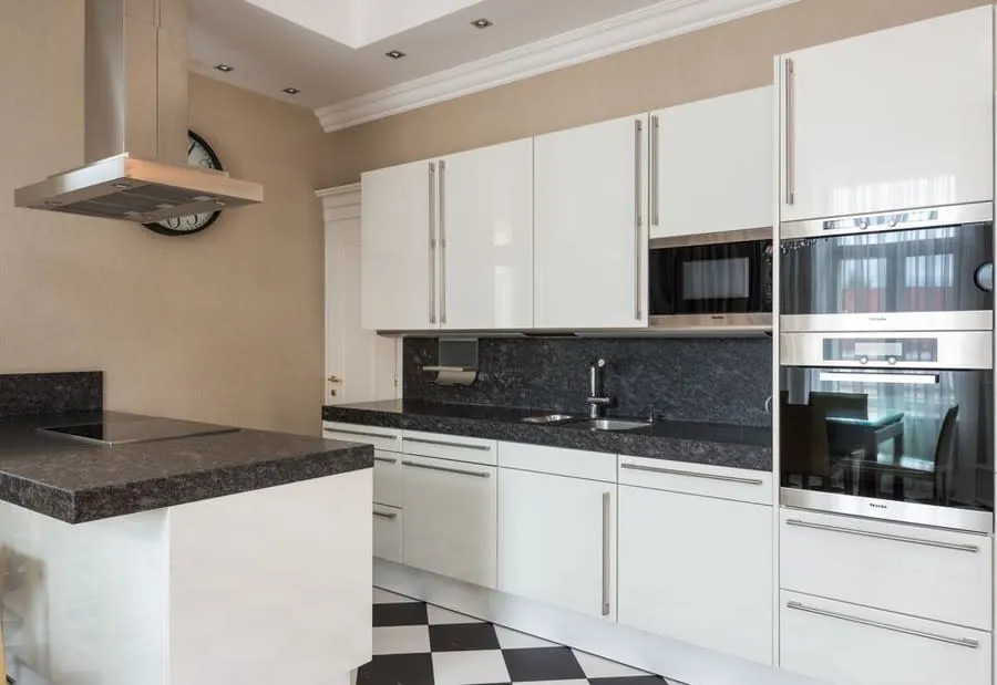 Modern fitted kitchen with a wall mounted cooker hood above the hob