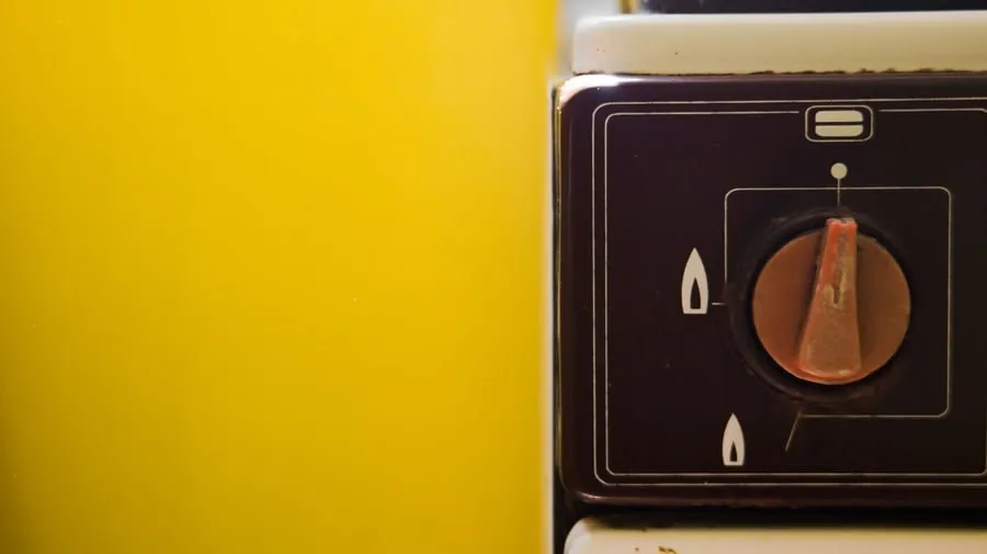 Close-up of a gas cooker control knob on a coloured stove front