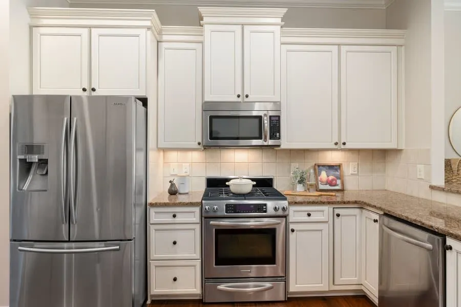 Modern kitchen with white cabinets, stainless steel appliances, and granite countertops