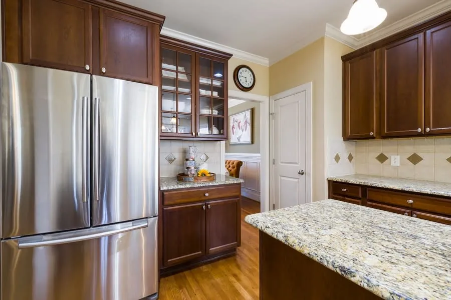Kitchen with timber cabinet doors and stainless steel appliances after a door replacement