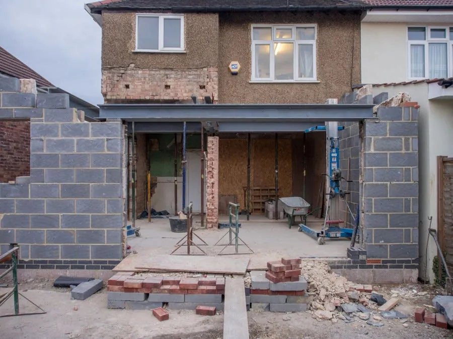 Brick house with a rear extension under construction and scaffolding in place