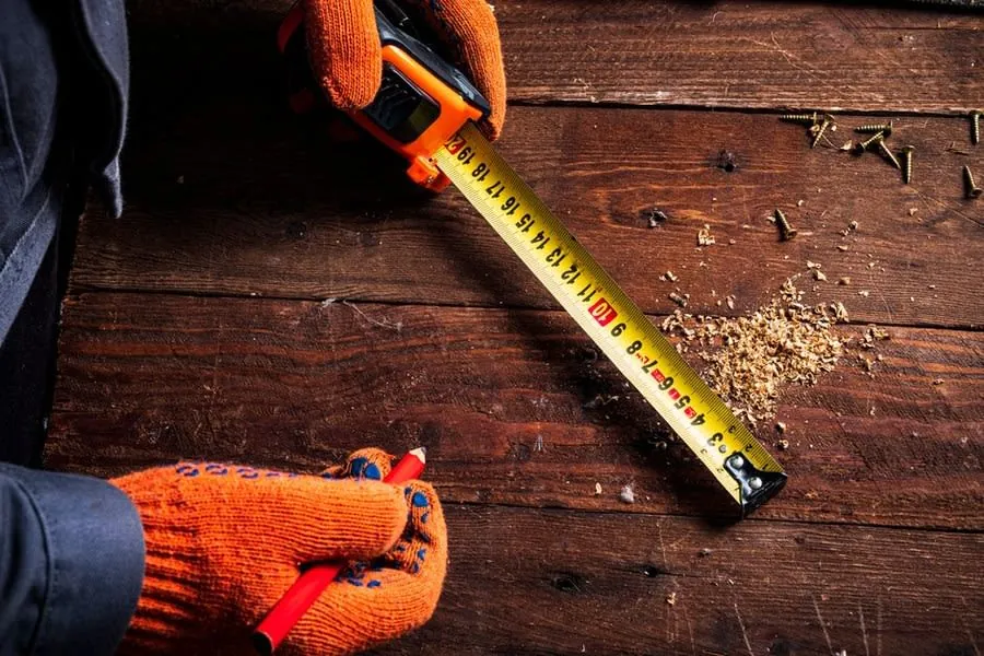 Kitchen fitter measuring a worktop with a tape measure before cutting, Liverpool