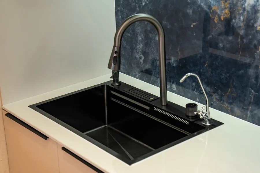 Modern kitchen sink with matte black basin, chrome faucet, and white countertop