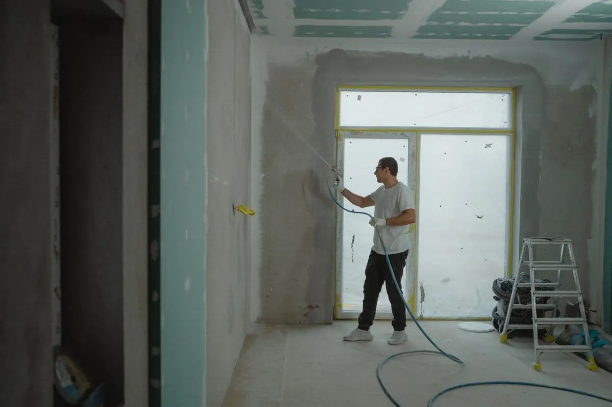 Tradesperson carrying out renovation work in a room being refitted