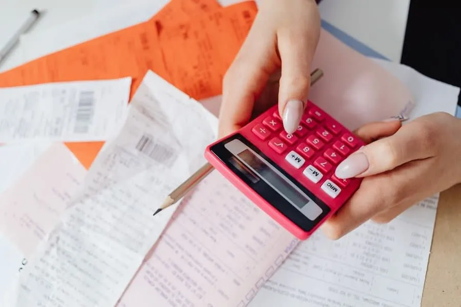 Homeowner working through kitchen quotes and receipts with a calculator in Liverpool