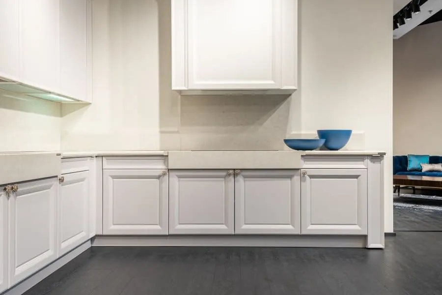 Showroom display of white kitchen units being considered by a Liverpool homeowner