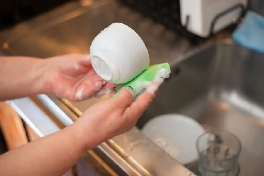 Washing up at a kitchen sink - the sink base unit below takes more water than any other part of the kitchen