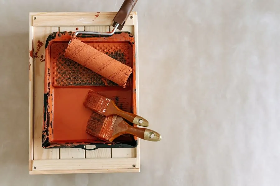 Paint roller and brushes in a tray ready for refinishing kitchen doors