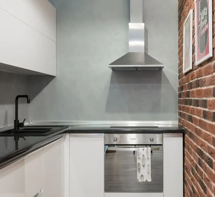 Simple white fitted kitchen units with laminate worktop in a rental property