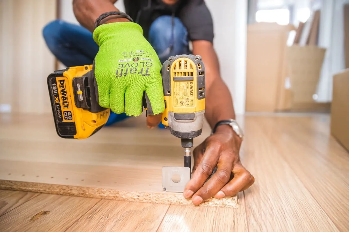 Kitchen fitter drilling into timber while installing units in a Liverpool home