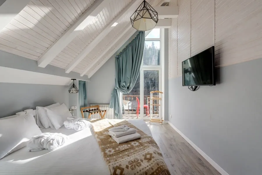 Finished loft bedroom with fitted storage and a large window