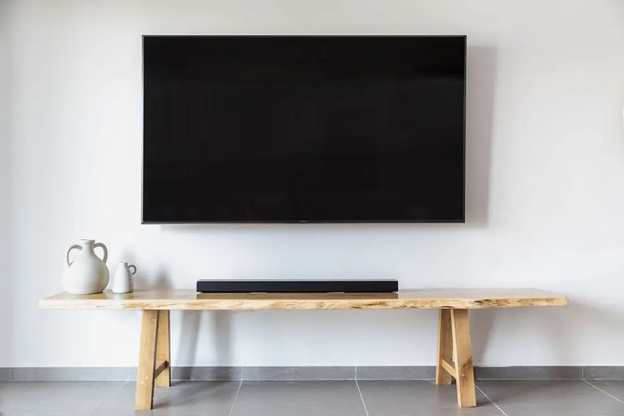 Minimalist media wall with a wall-mounted flat screen TV and wooden console