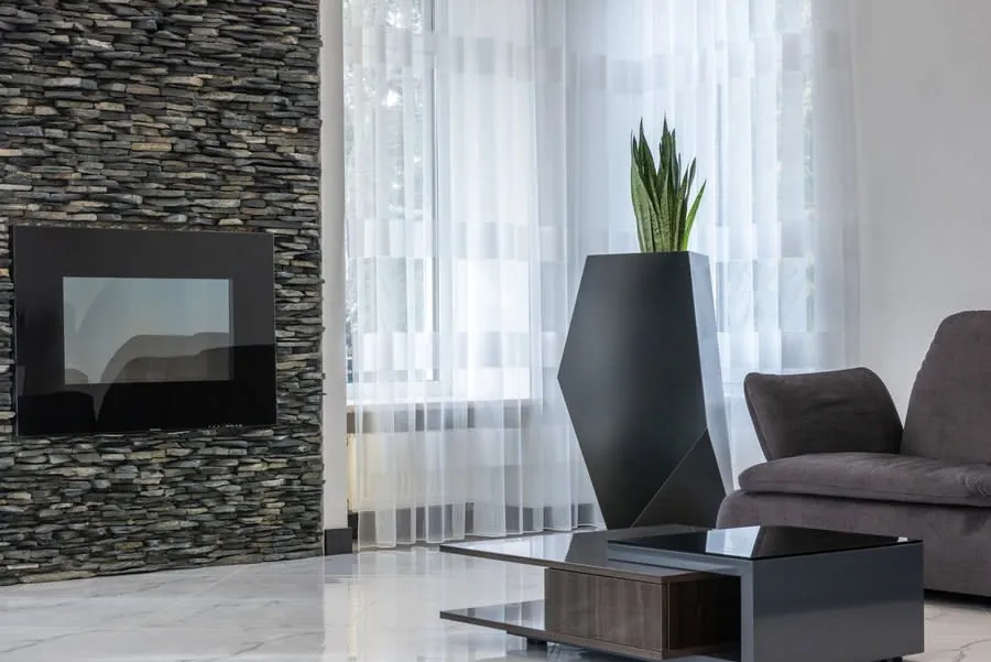 Electric fireplace set into a stone-effect feature wall in a modern living room