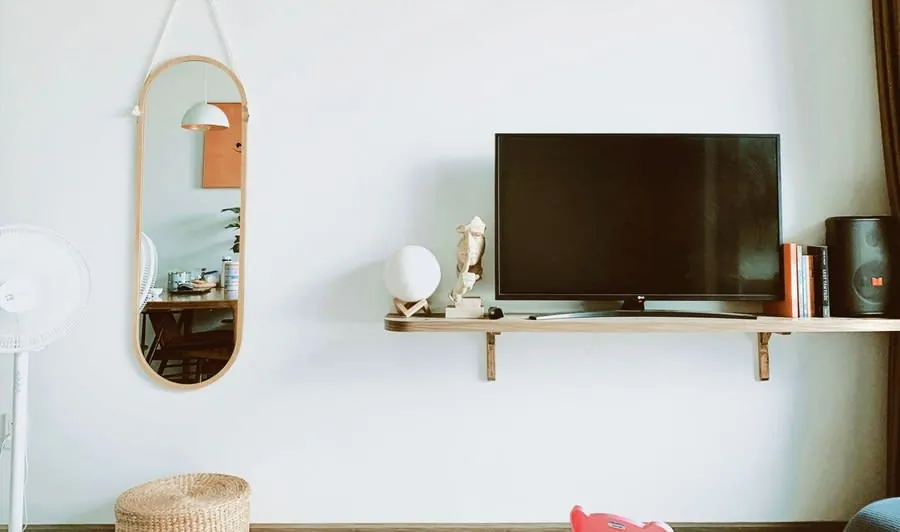 Wall-mounted television recessed into a clean white feature wall