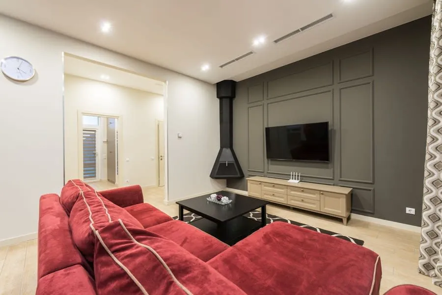 Contemporary living room with a large TV mounted flush on a grey feature wall