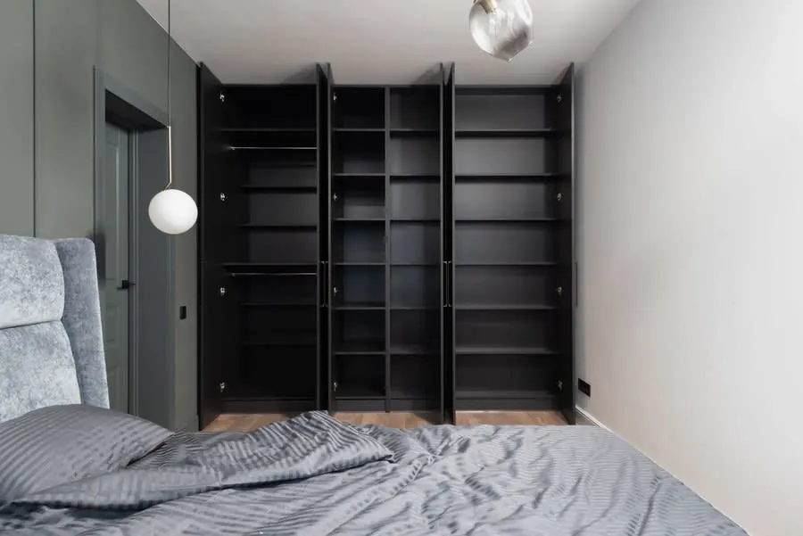 Bedroom with open-fronted fitted wardrobes along one wall