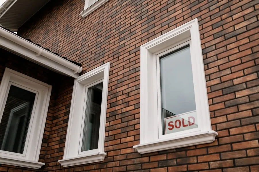 Brick house with a sold board in the front window