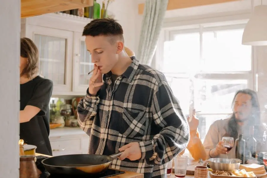 Three housemates cooking together in a shared kitchen, typical of a Liverpool HMO