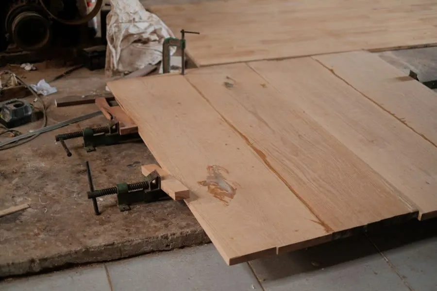 Clamped timber boards on a workshop bench during bespoke kitchen joinery