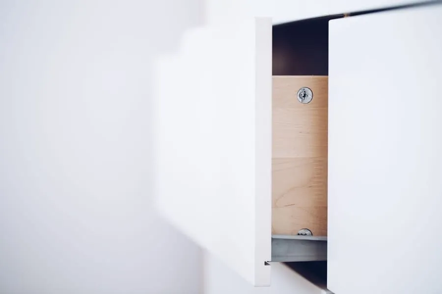 Open drawer showing the wooden carcass interior and fixings of a fitted unit