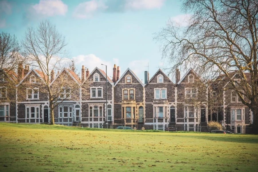 Row of red brick Victorian terraced houses with bay fronts on a residential street
