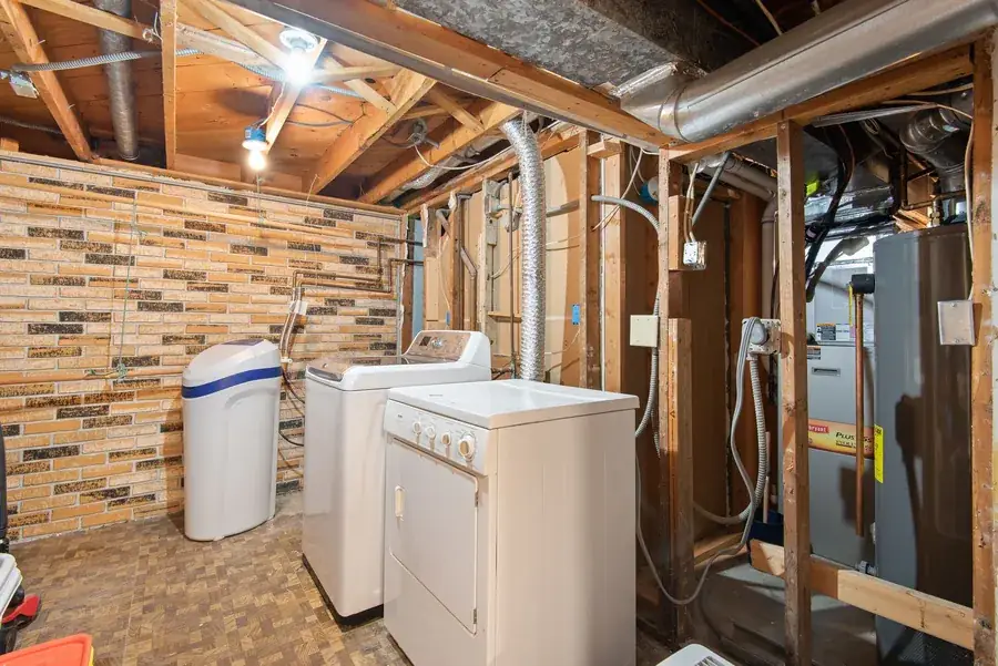 Basement laundry area with exposed brickwork and appliances, similar to a cellar utility in a Liverpool terrace