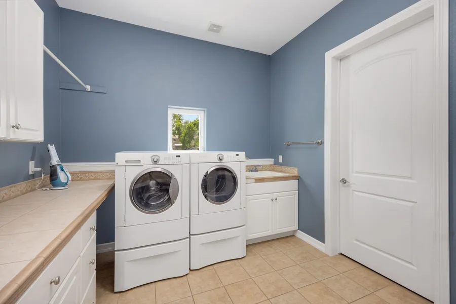 Fitted utility room units and worktop with laundry appliances installed in a Liverpool property