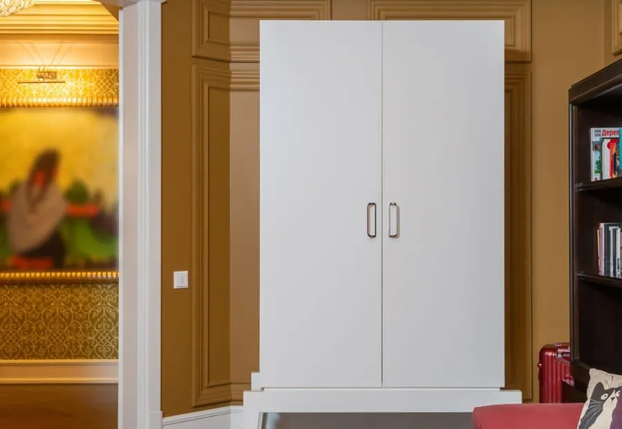 Sleek white fitted wardrobe with wood panelling in a modern room