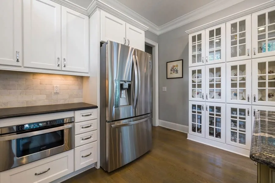 Tidy contemporary kitchen with white cabinet fronts in sound condition