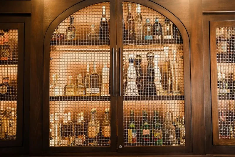 Wooden drinks cabinet with fitted shelving for bottles and glassware