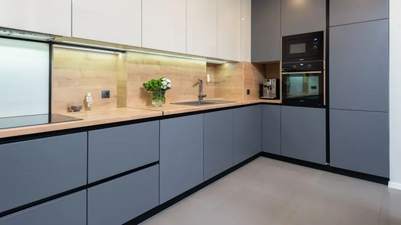 Open plan kitchen with grey units and wood worktop in a Liverpool home after a knock through