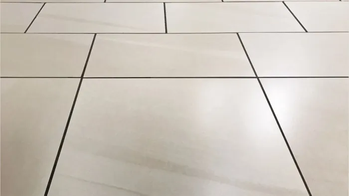 Tiled floor with black grout lines, perspective view receding toward the horizon.