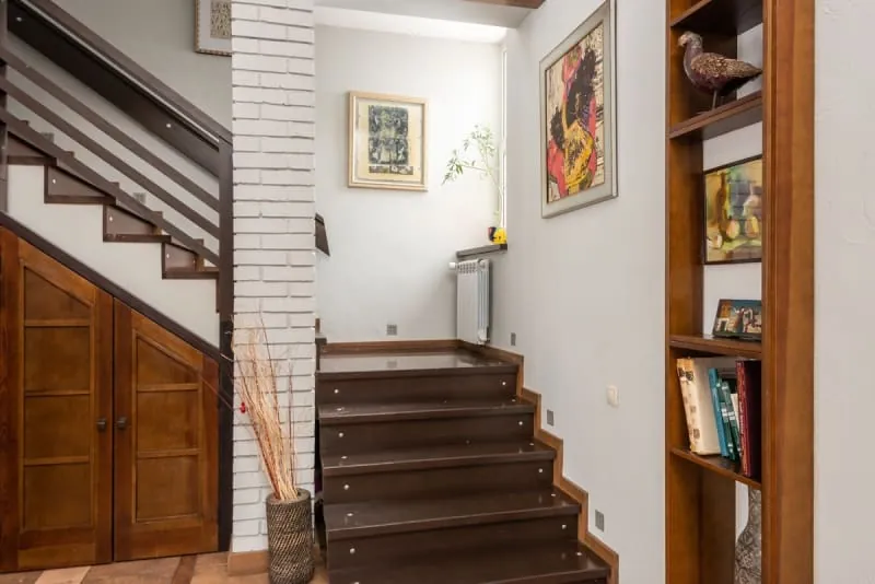 Modern hallway with staircase and fitted wooden shelving unit