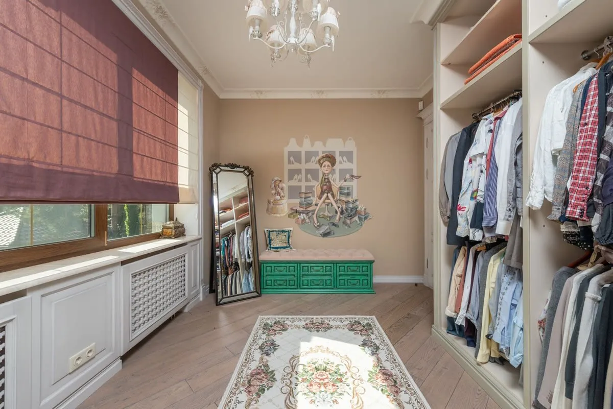 Fitted walk-in wardrobe with open hanging rails and shelving in a Liverpool box room