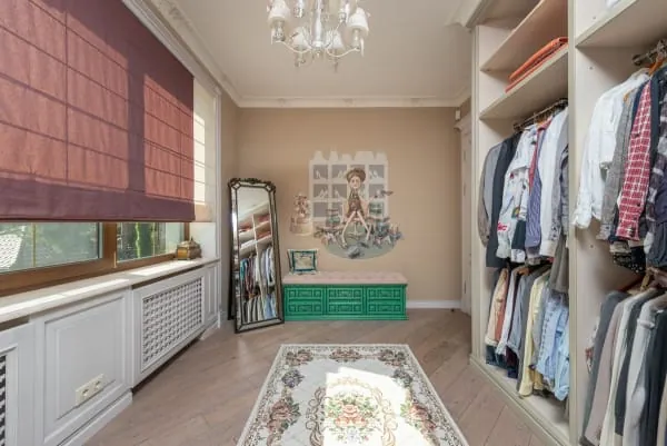 Walk-in wardrobe with open shelving, hanging rails and a mirror